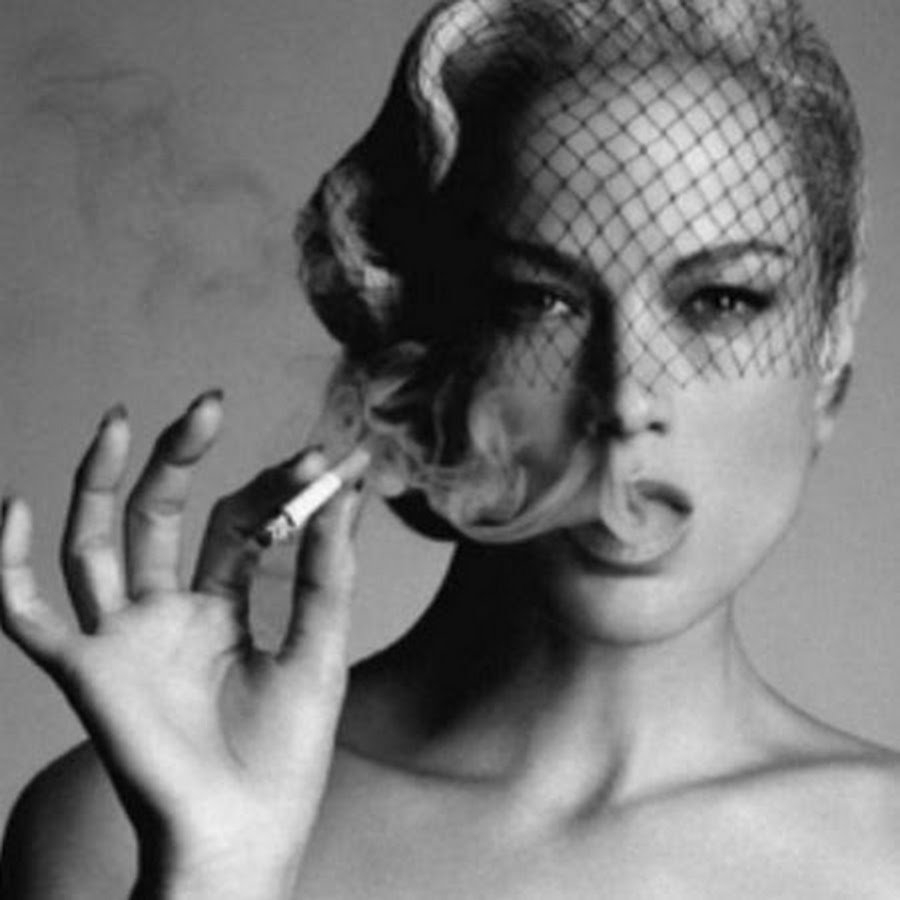 The woman smokes on the balcony