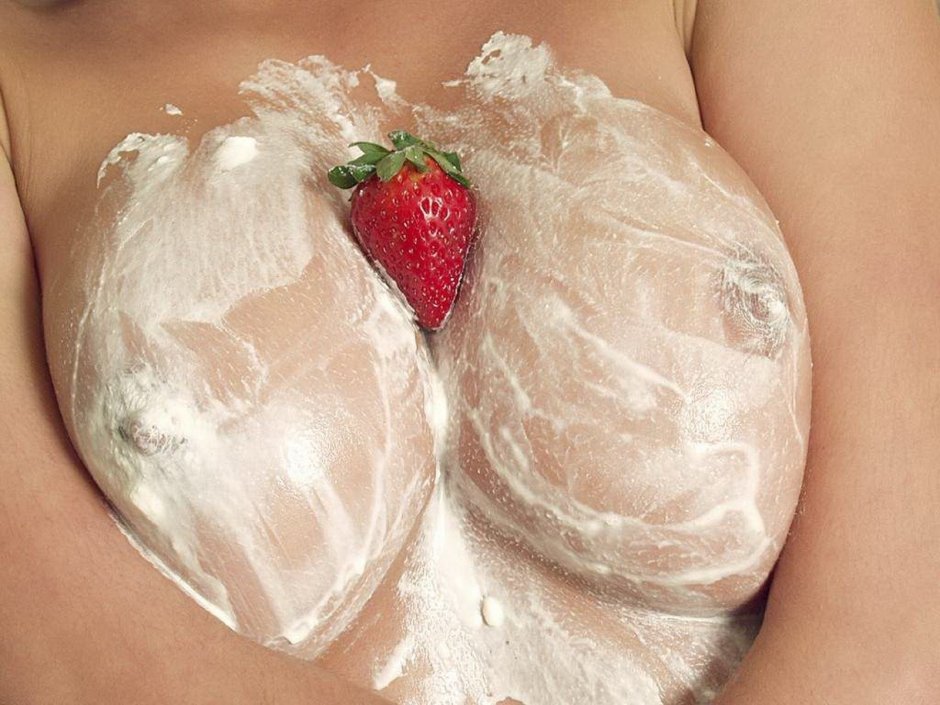 Strawberries with cream on the body of a girl