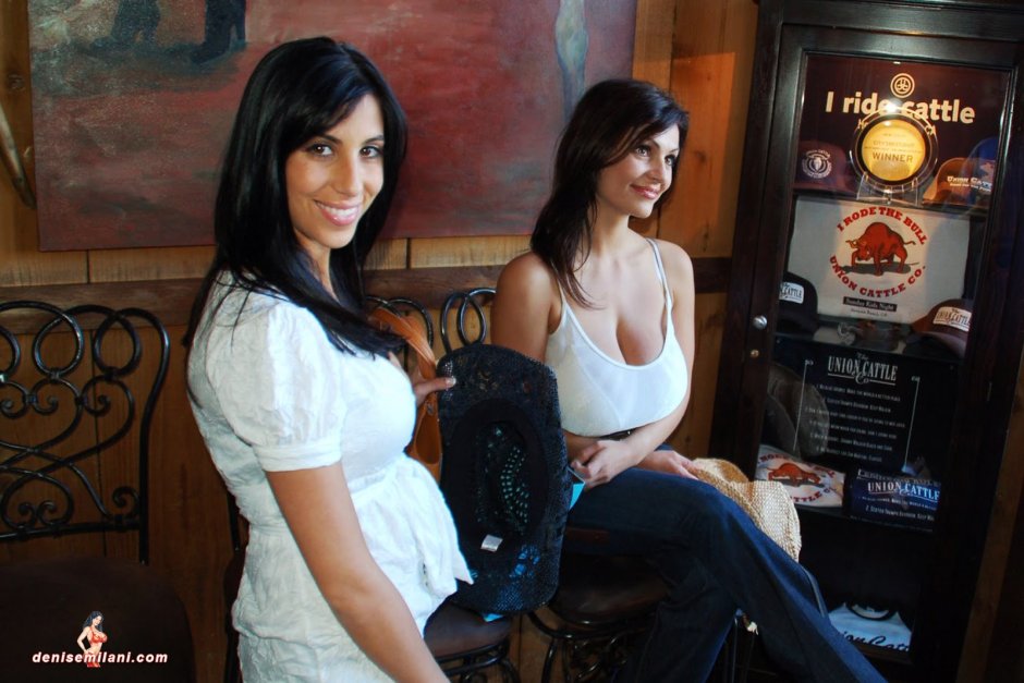 Denise Milani on a red couch