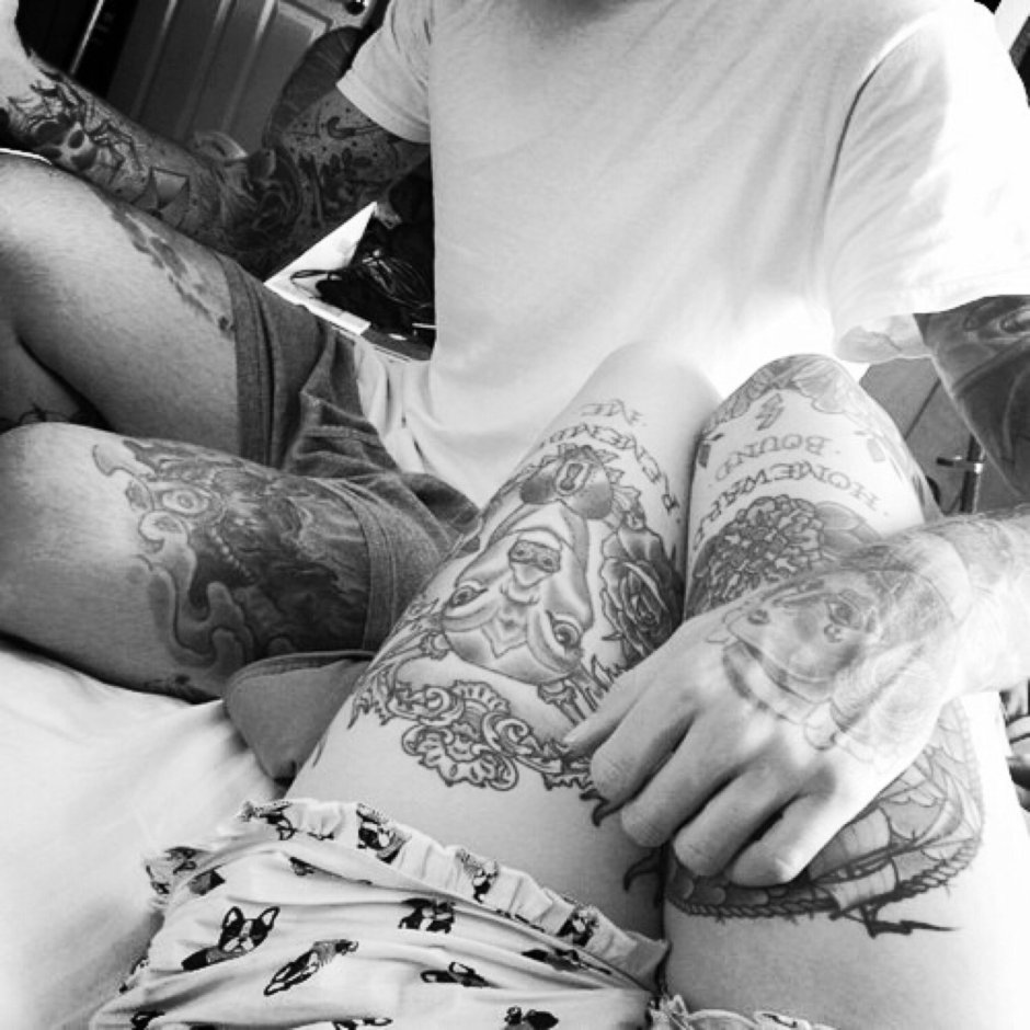 A guy with a tattoo on the bed