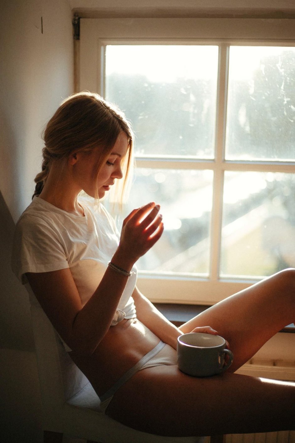 Girl with a cup by the window