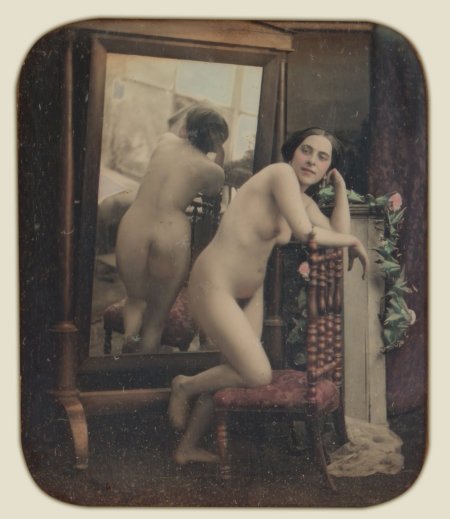 Naked women in front of a retro mirror