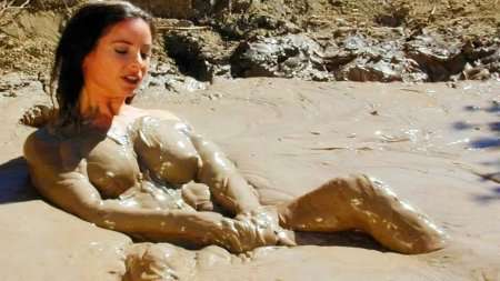 Naked woman in a mud bath