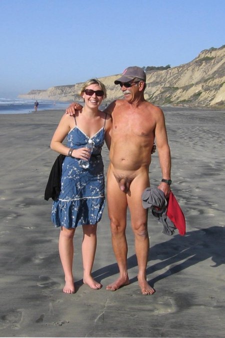 Naked man clothed woman on the beach