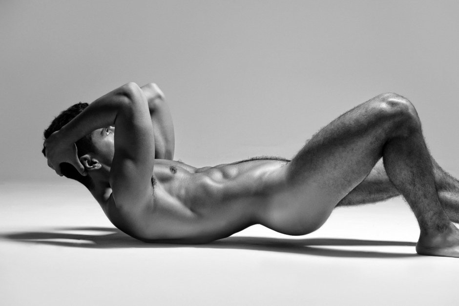 A naked man lies on the bed