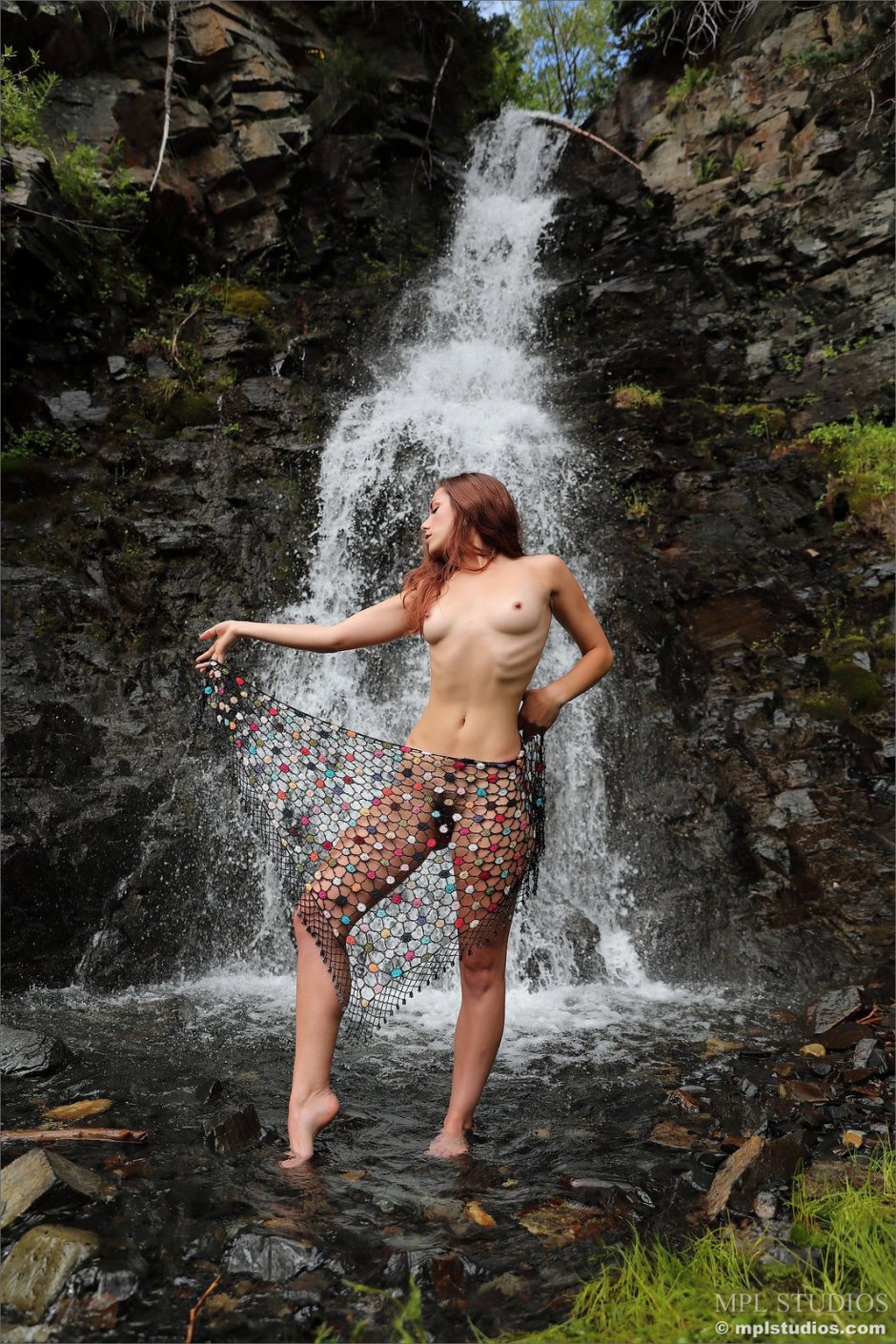 Naked women under a waterfall