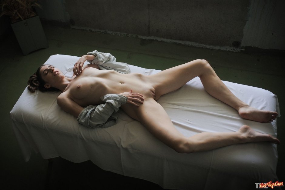 Голая телка с плоским животиком лежит