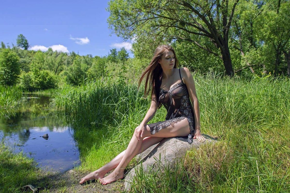 Очаровательная голая девушка возле реки