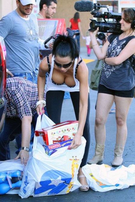 Girl bent over in the trunk of a car