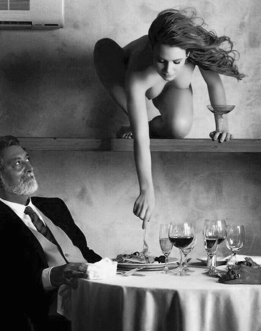 Голая женщина сидит за столом