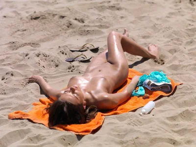 Голые женщины загорают на пляже