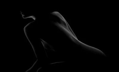 Силуэт обнаженной девушки на черном фоне