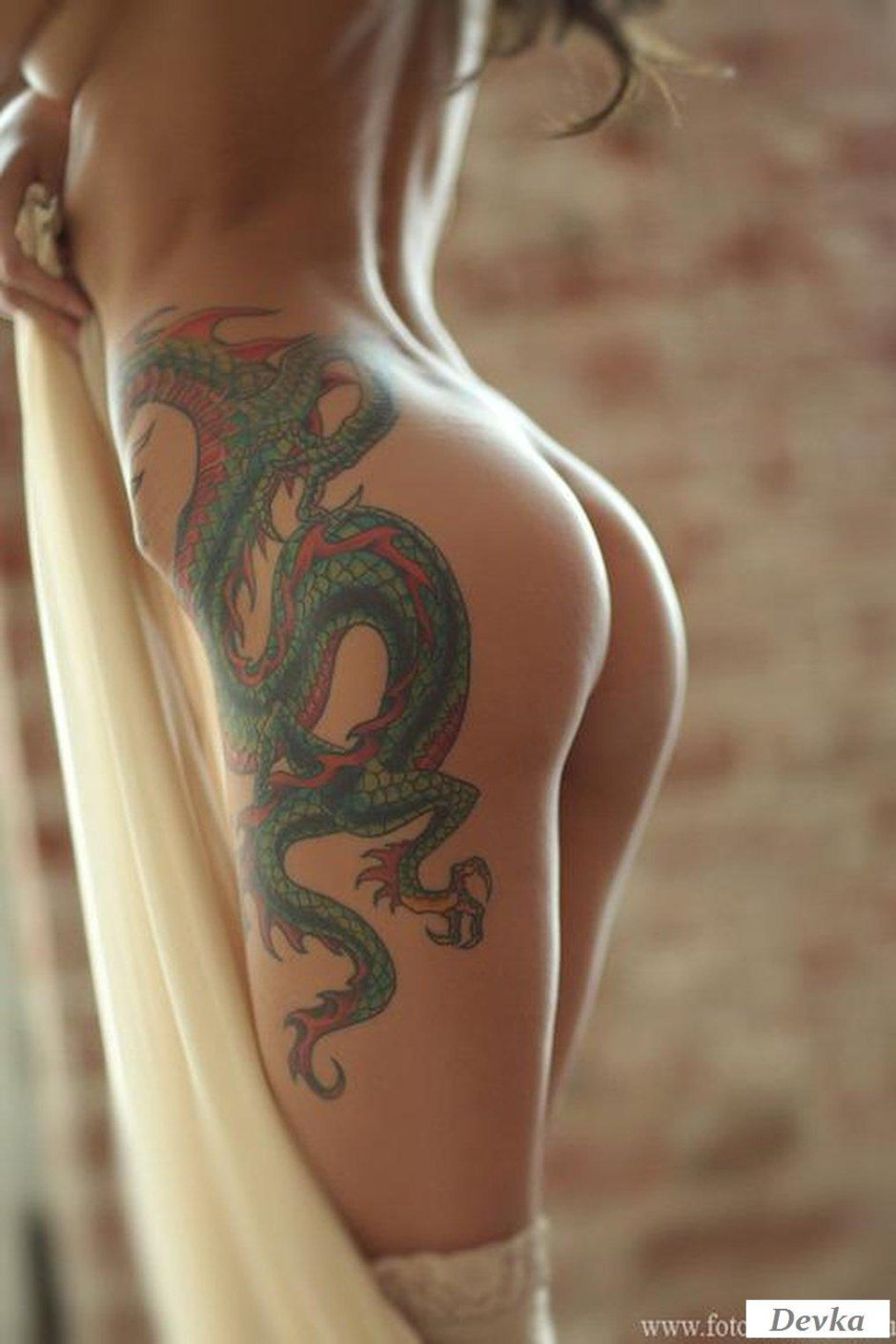 Тату дракона на бедре