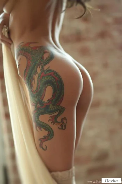 Тату дракона на бедре