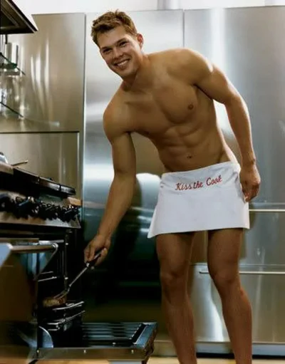 Мужчина в фартуке на кухне соблазнительно