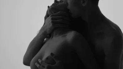 Мужчина ласкает грудь женщины