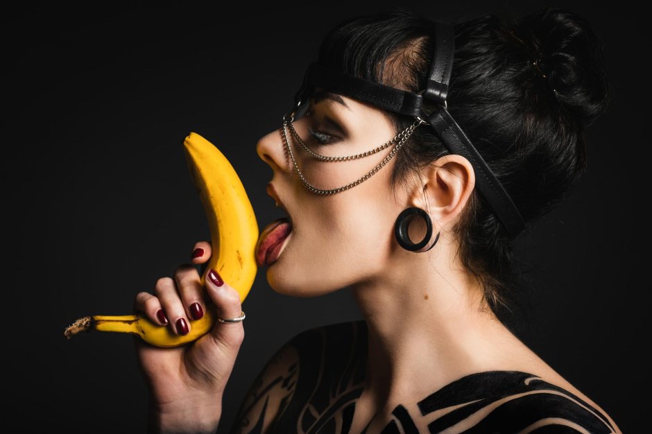 Девушка облизывает банан