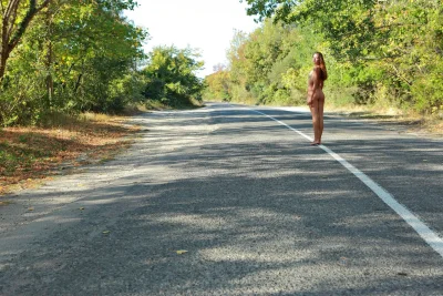 Девушка голосует на дороге ню