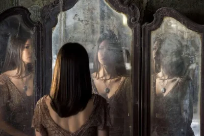 Женщина смотрит в зеркало