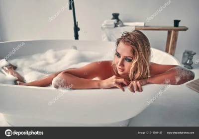 Молодая блондинка расслабляется в ванной