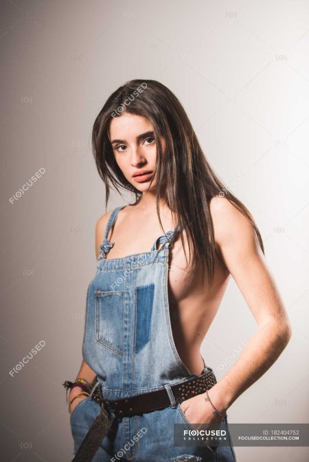 Brunette topless girl posing in jeans studio